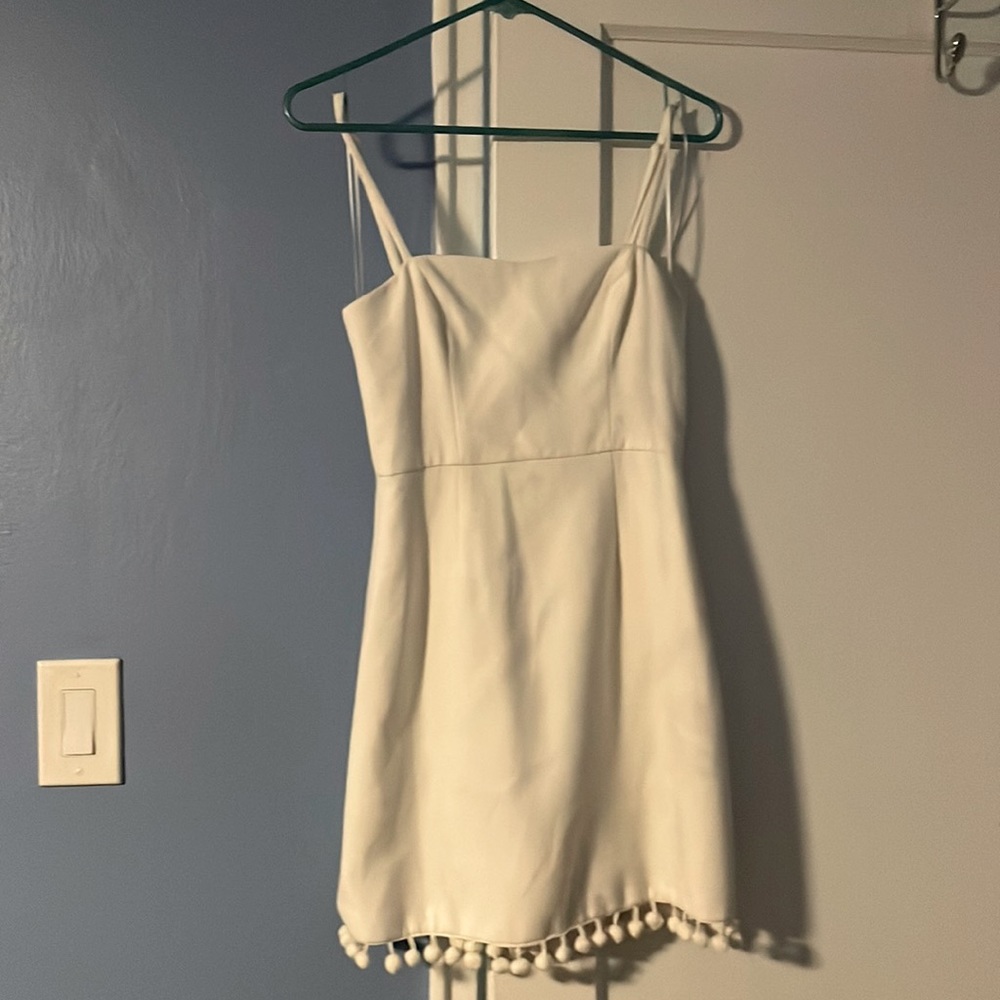 Cute white dress with pompon trim.